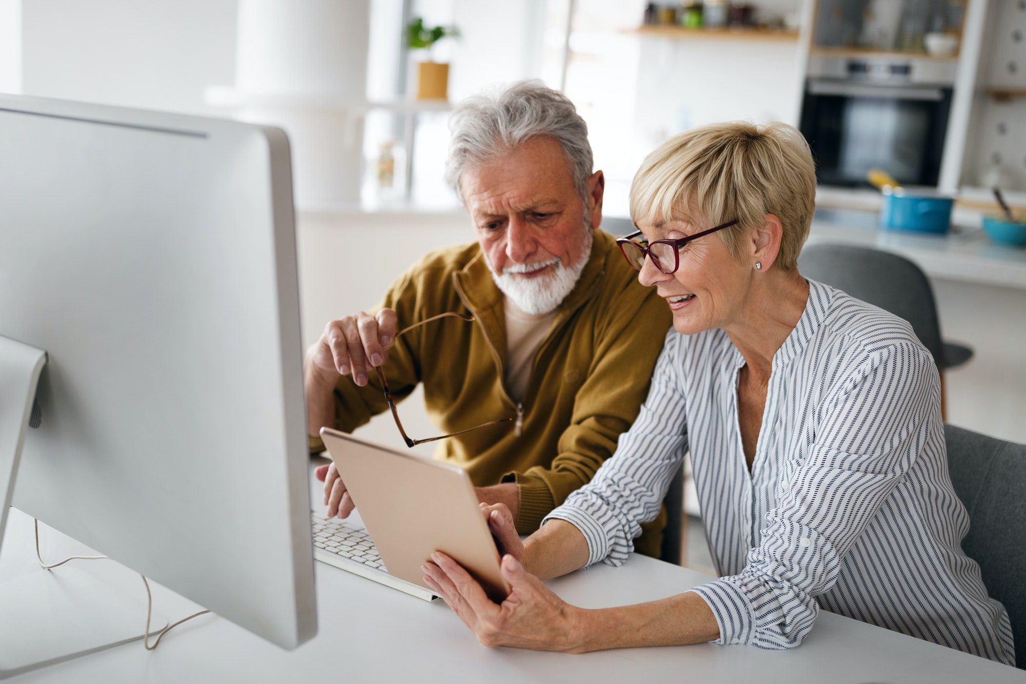 Senior woman helping explain Medicare Part B Giveback to senior man.