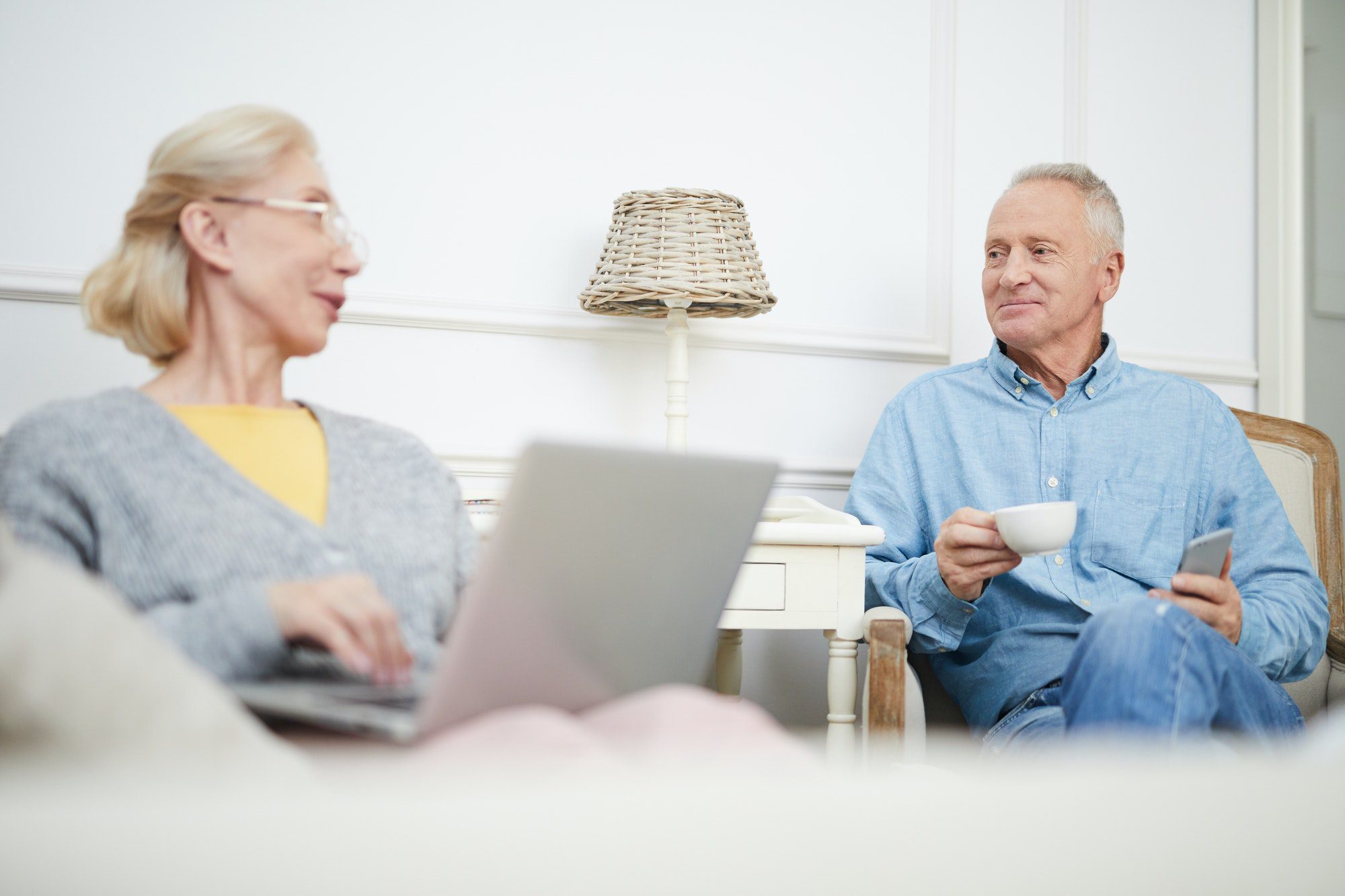 Seniors enjoying relaxing time in living room as they discuss which Medicare Agent might be a fit for them.