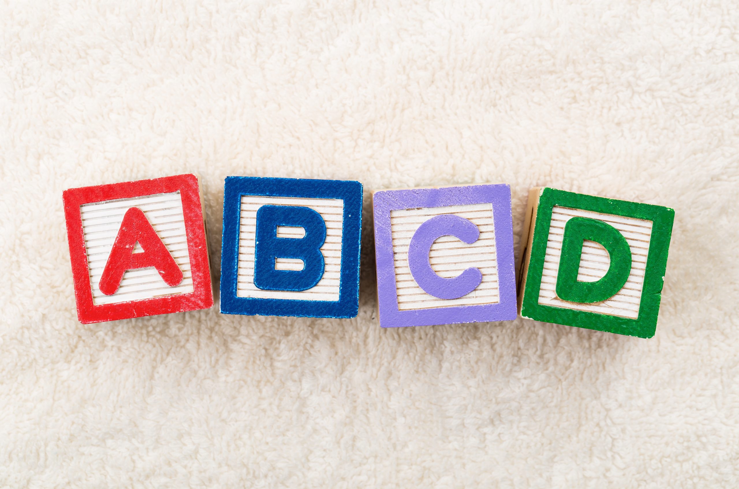 Wooden toy Blocks with the text: abc representing the parts of medicare.