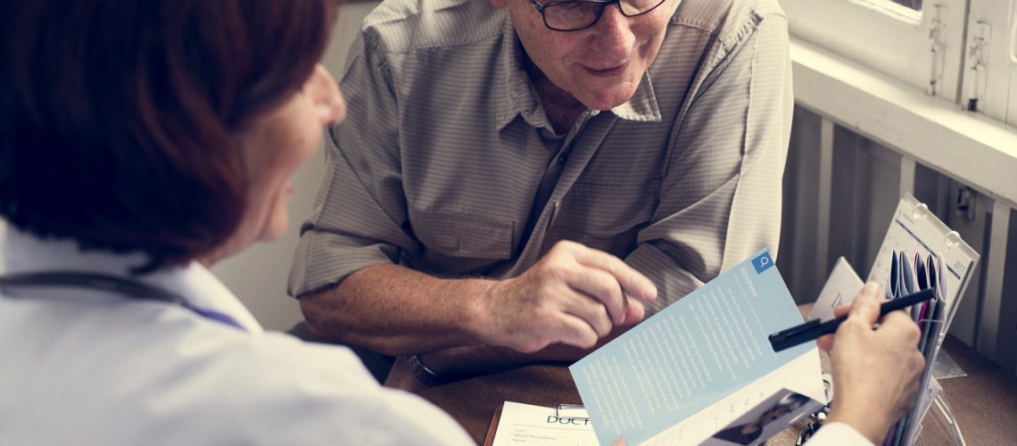 Happy elderly patient meeting with doctor to discuss the good and bad of Medicare Advantage.