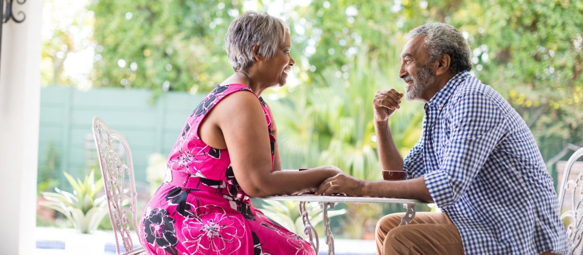 Happy senior couple sitting at table discussing social security and medicare